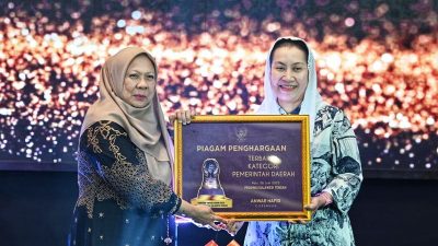 Wakil Gubernur Sulawesi Tengah, dr. Reny A. Lamadjido, Sp.PK., M.Kes, menyerahkan Paritrana Award kategori pemerintah kabupaten/kota terbaik kepada Wakil Wali Kota Palu, Imelda Liliana Muhidin, S.E., M.A.P. (Foto : Ro Adpim Setdaprov Sulteng)